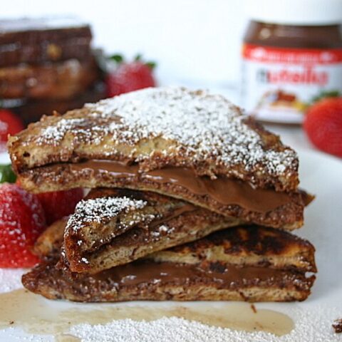 french toast with nutella stacked on a plate with powdered sugar on top