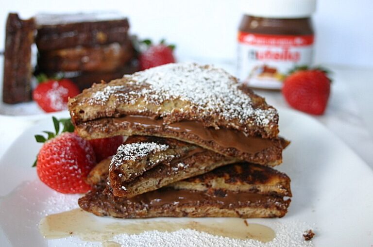 french toast with nutella stacked on a plate with powdered sugar on top