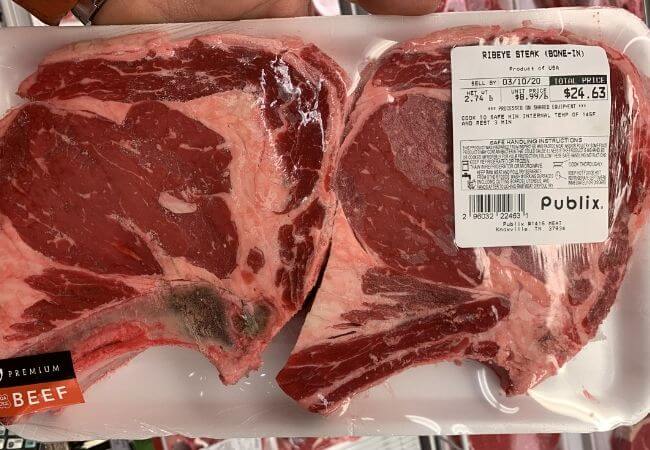 two USDA Choice ribeye steaks with fat marbling throughout