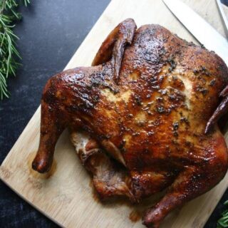 smoked whole chicken on a cutting board