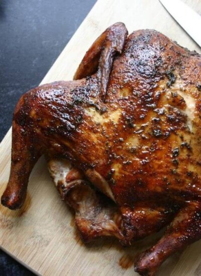 smoked whole chicken on a cutting board