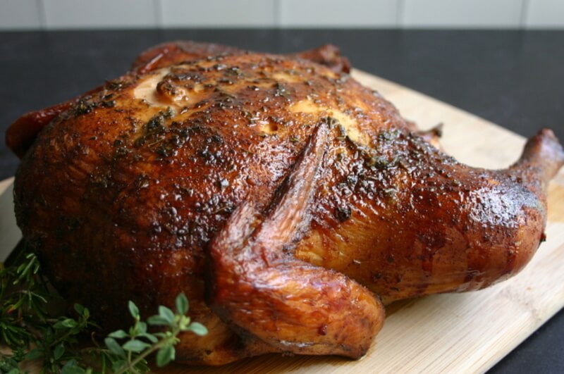 smoked whole chicken on a cutting board