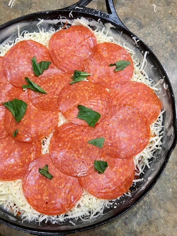 raw pizza in a cast iron skillet