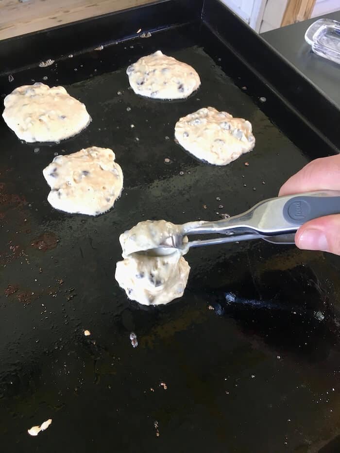 muffin mix pancake batter being spooned on a flat top grill