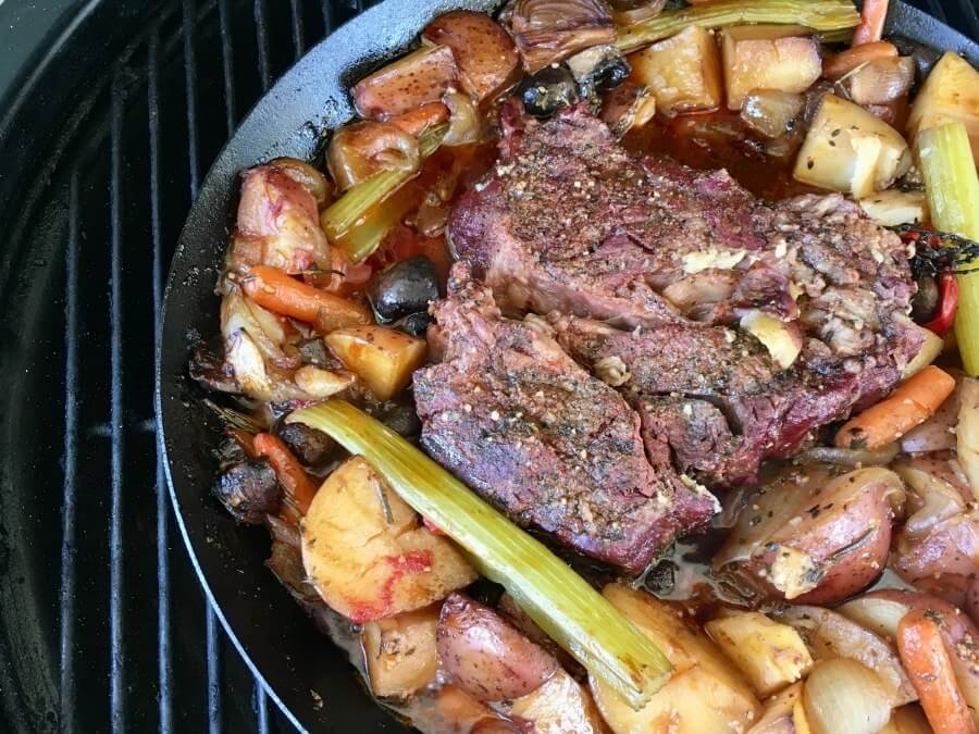 smoked pot roast with vegetables on a charcoal grill