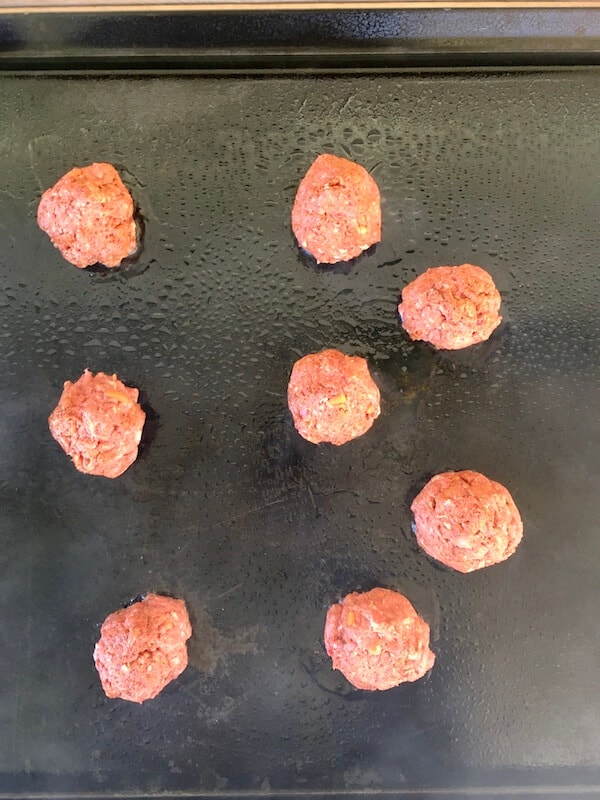 uncooked taco smash burgers on a flat top grill