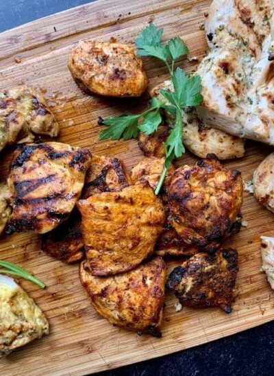 charcoal grilled chicken breasts on a cutting board