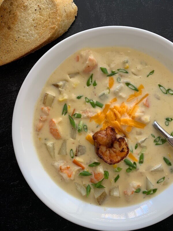 creamy shrimp and corn soup in a bowl with bread