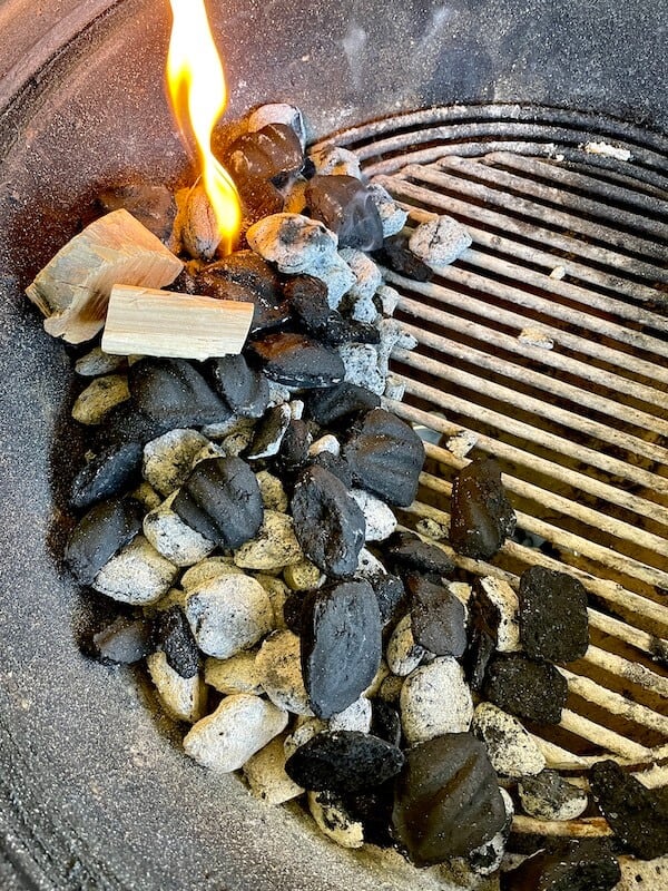 charcoal and wood chunks smoking in a charcoal grill