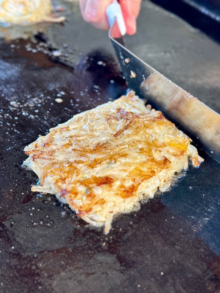 forming hash brown casserole mix into a square shape on the griddle