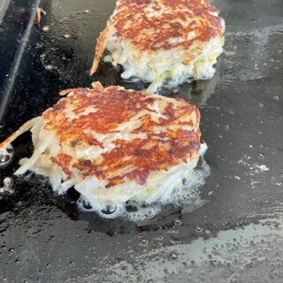 hashbrown casserole cakes on a flat top grill