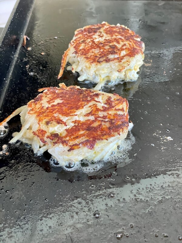 hashbrown casserole cakes on a flat top grill