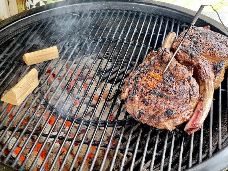 2 thick steaks on the cool side of a charcoal grill