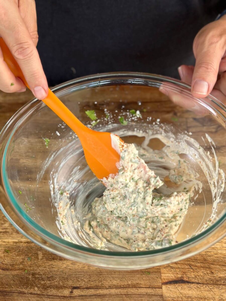 mixing mayo, Cotija cheese, cilantro, and lime juice in a bowl