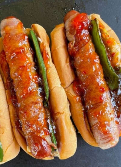 bacon wrapped jalapeno popper hot dogs with hot pepper jelly on top
