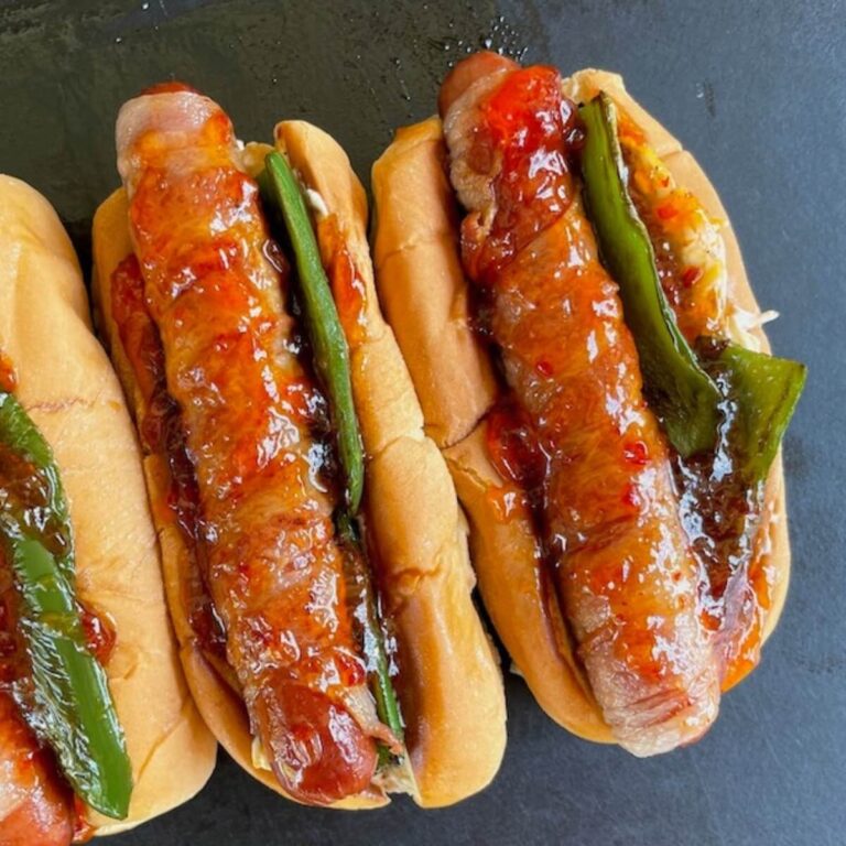 bacon wrapped jalapeno popper hot dogs with hot pepper jelly on top