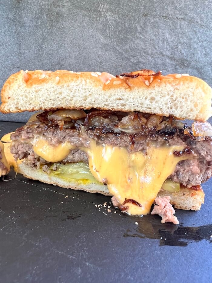 Juicy Lucy burger cut in half with cheese melting