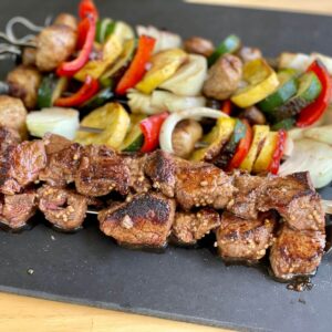 steak and vegetable kebabs cooked on a griddle