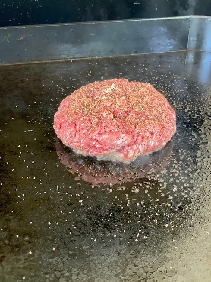 Boursin burger cooking on a griddle