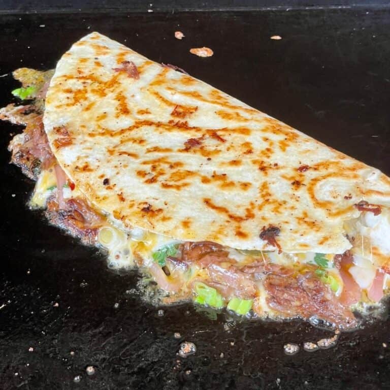 brisket quesadilla cooking on a griddle