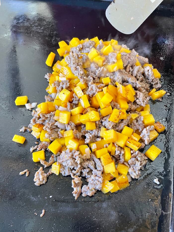 ground sausage and butternut squash on a blackstone griddle