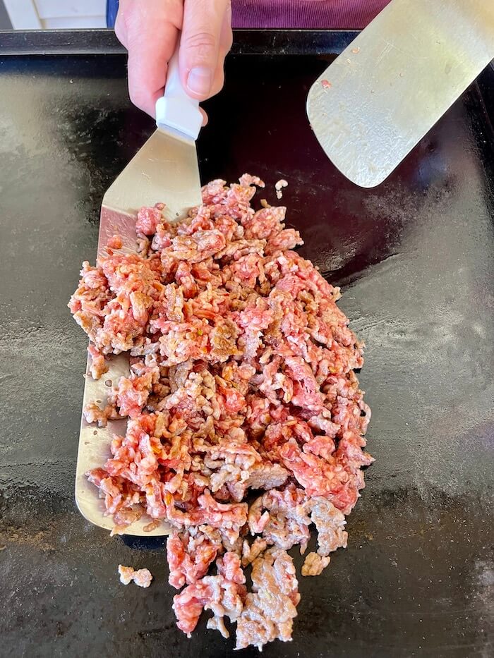 ground sausage cooking on a griddle