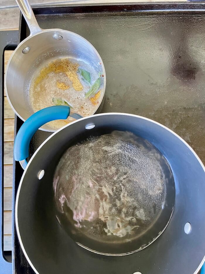 pot of boiling water and pot of butter melting on a griddle