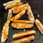 fried pickle spears cooking on a griddle