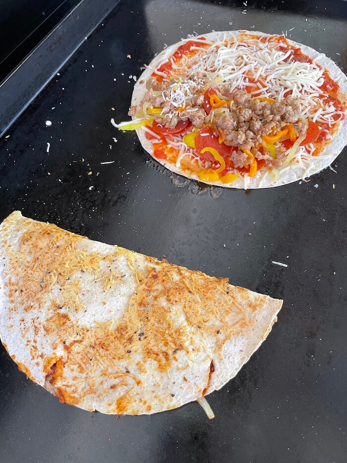 pizza quesadillas cooking on a griddle