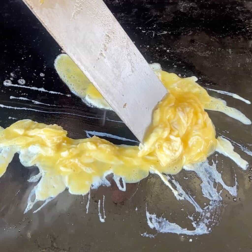 cooking scrambled eggs on the griddle