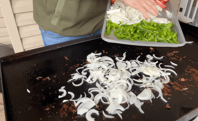 adding onions to a Blackstone griddle