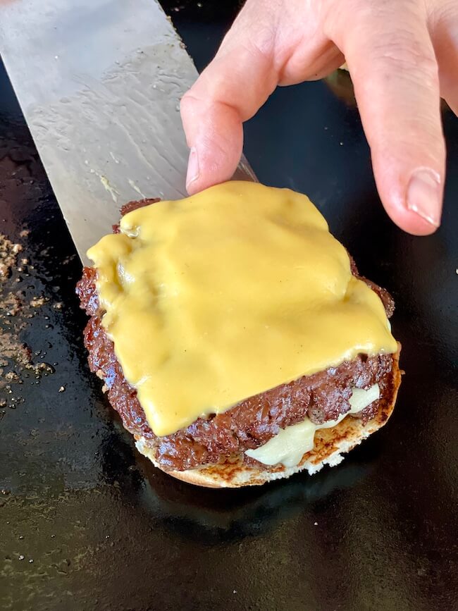 placing smash burgers on a burger bun