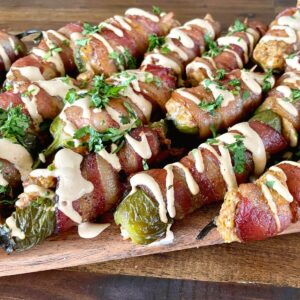 smoked bacon wrapped jalapeno poppers on a serving board