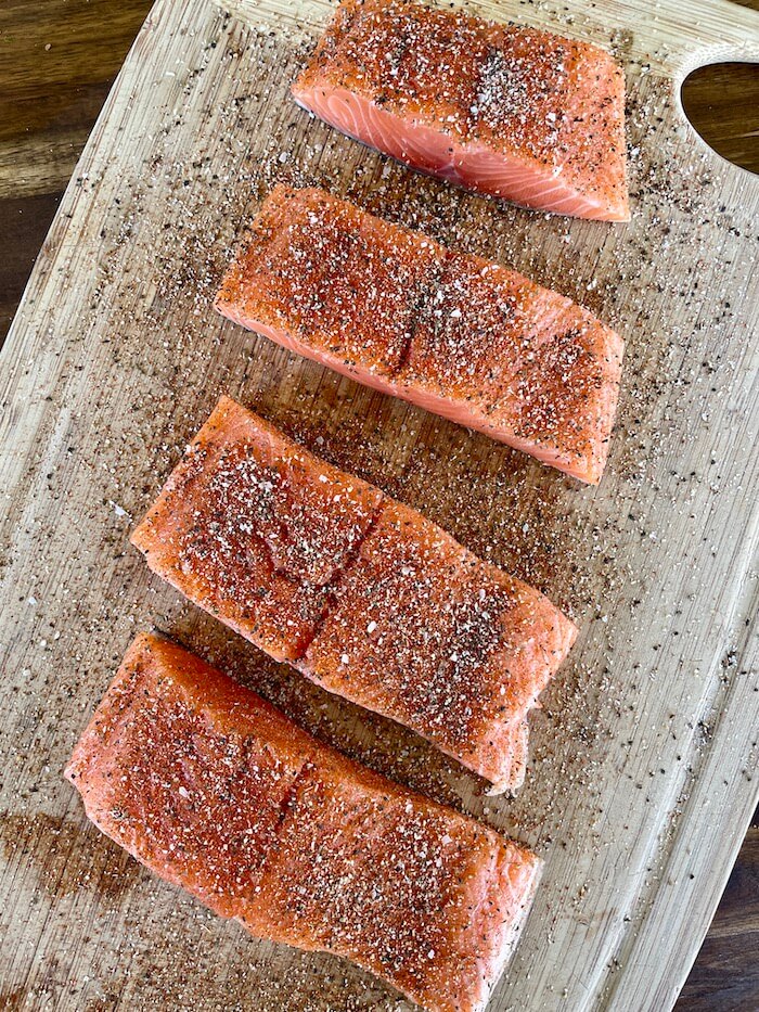 seasoned salmon filets on a cutting board
