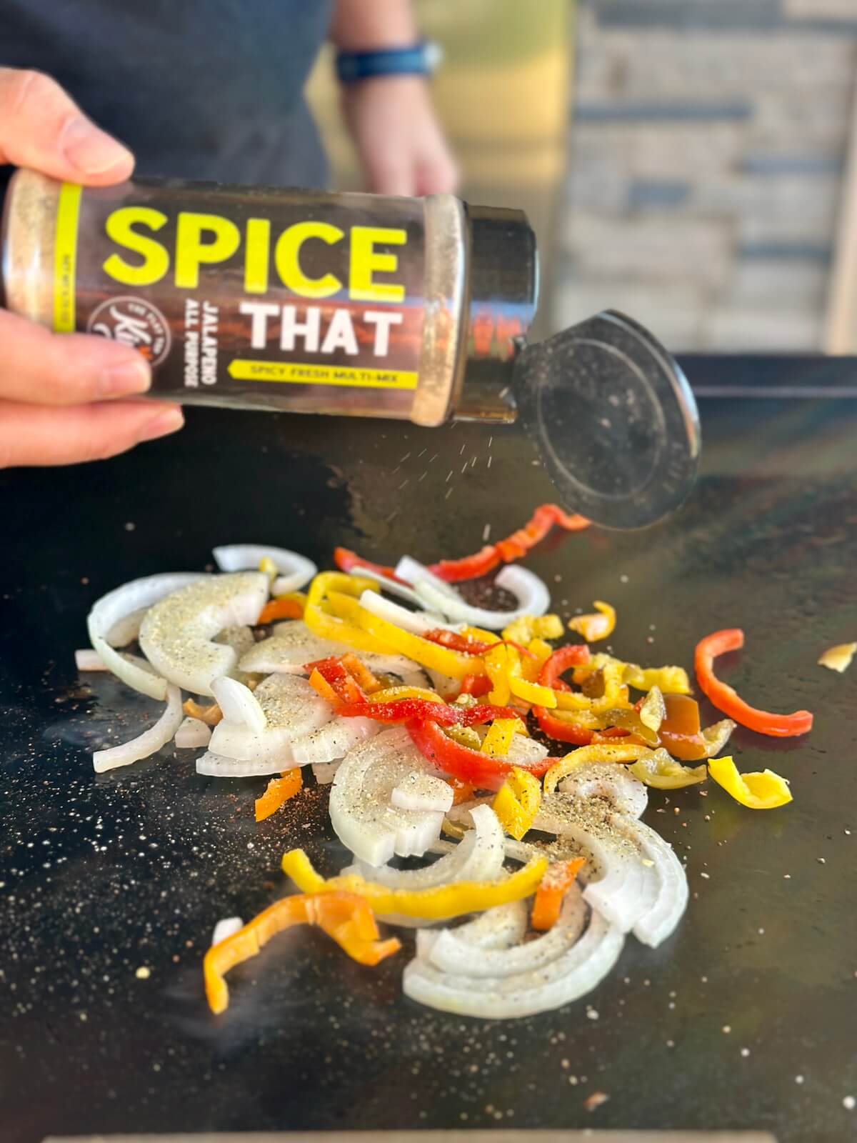 seasoning sliced bell peppers and onions