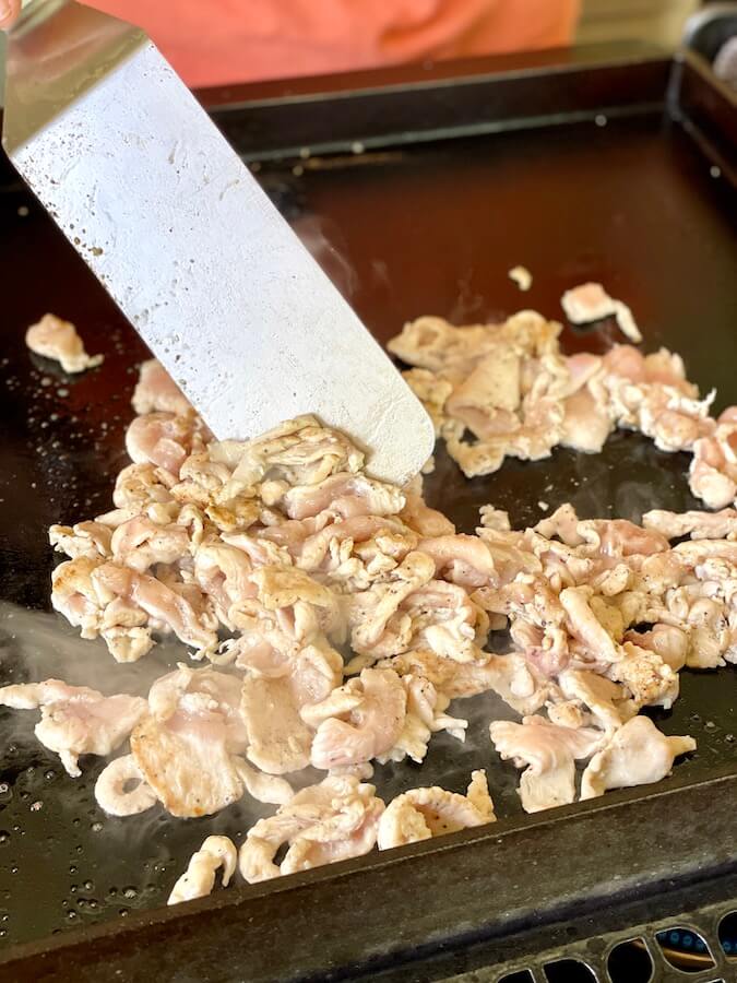 chicken strips cooking on a blackstone griddle