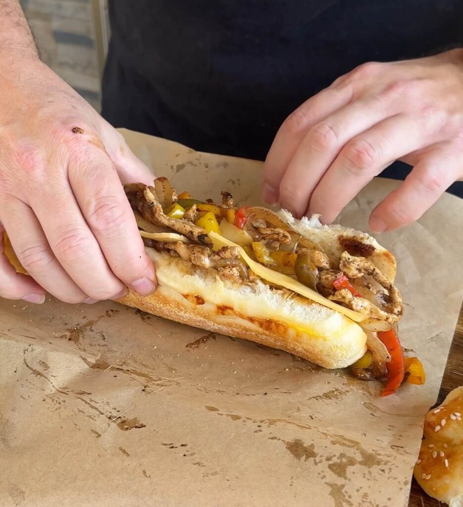 wrapping a chicken philly cheesesteak sandwich in deli paper