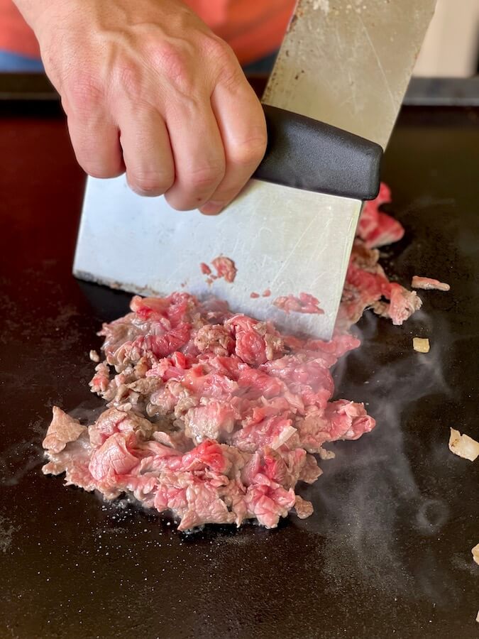 chopping ribeye steak on a blackstone griddle