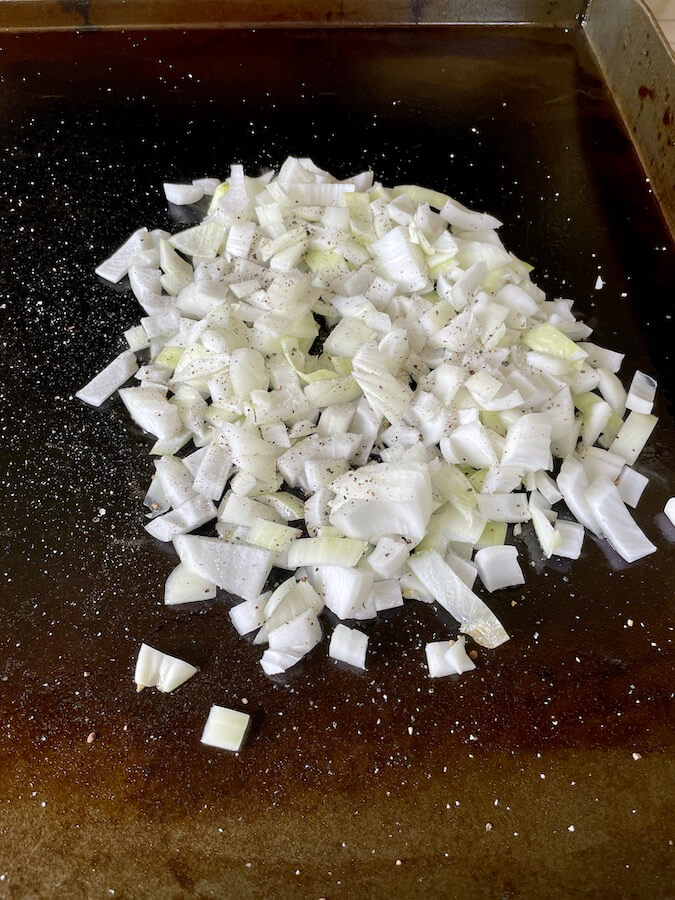 diced onions cooking on a blackstone griddle