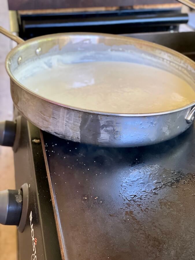 cooking homemade alfredo sauce on the blackstone griddle