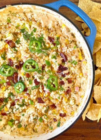 smoked street corn dip in a cast iron skillet with tortilla chips