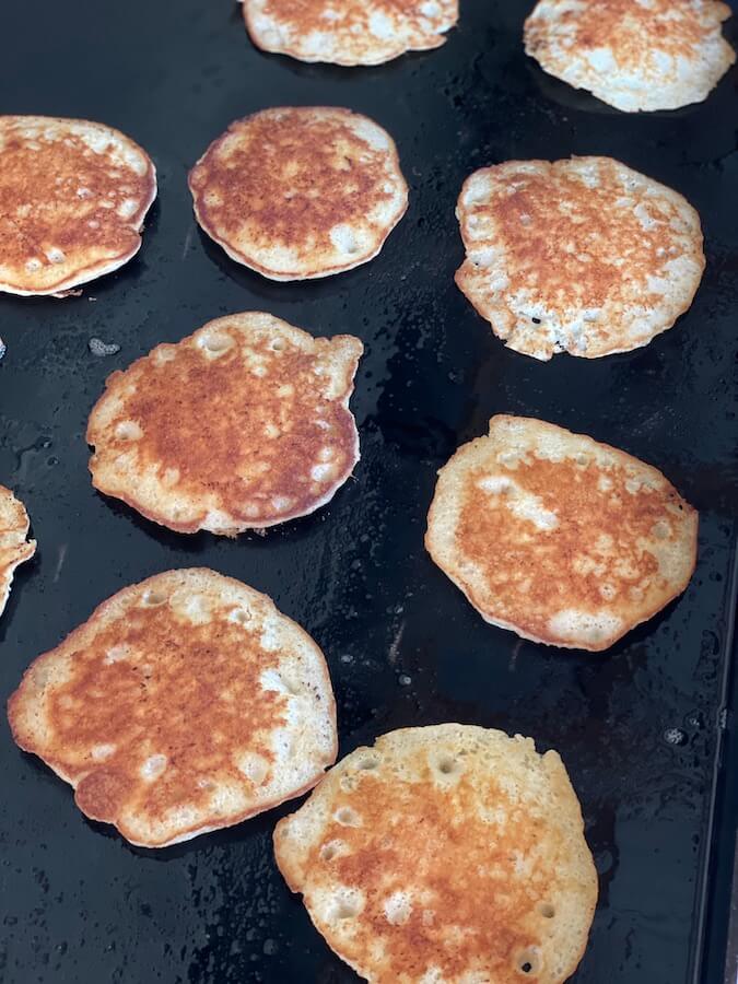 pancakes cooking on the griddle in butter