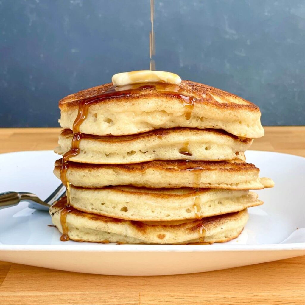 stack of griddle pancakes with butter and syrup