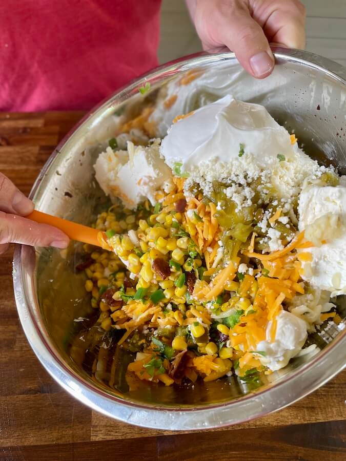 mixing street corn dip ingredients in a bowl
