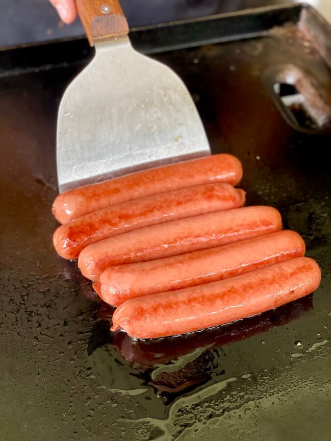 cooking hot dogs on a griddle