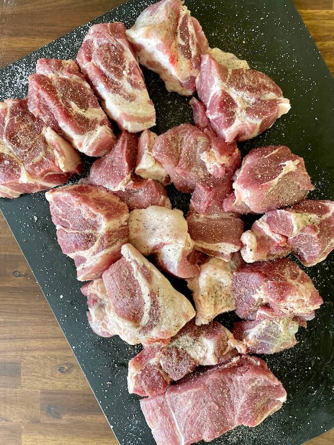 cut pork shoulder seasoned with salt and pepper