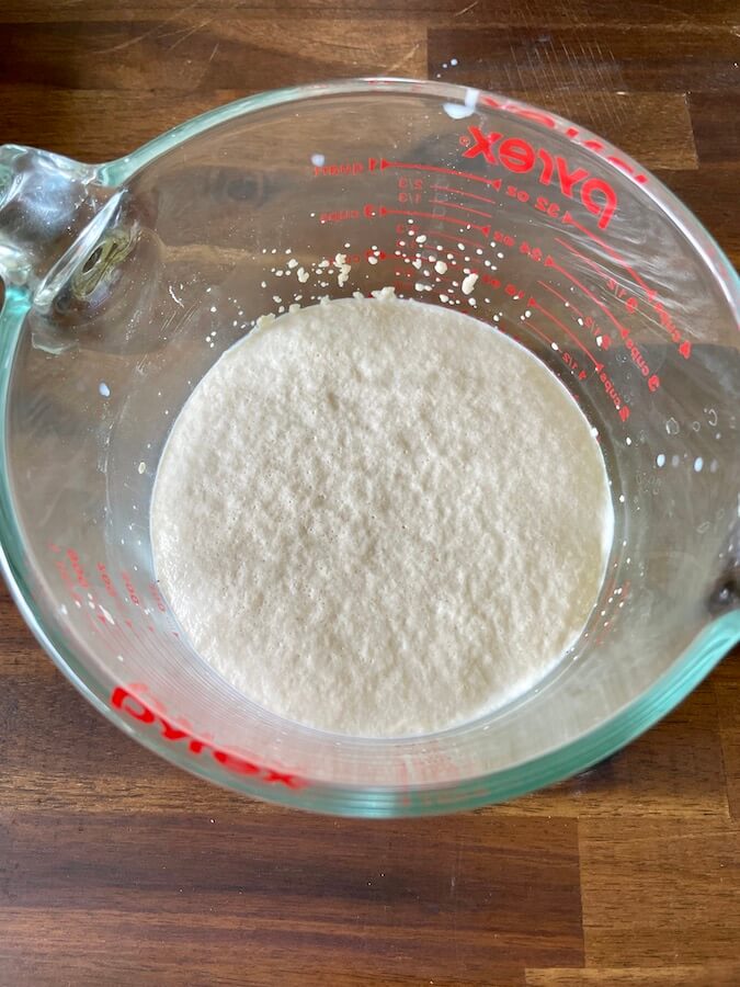 yeast mixed with sugar, water, and milk in a bowl