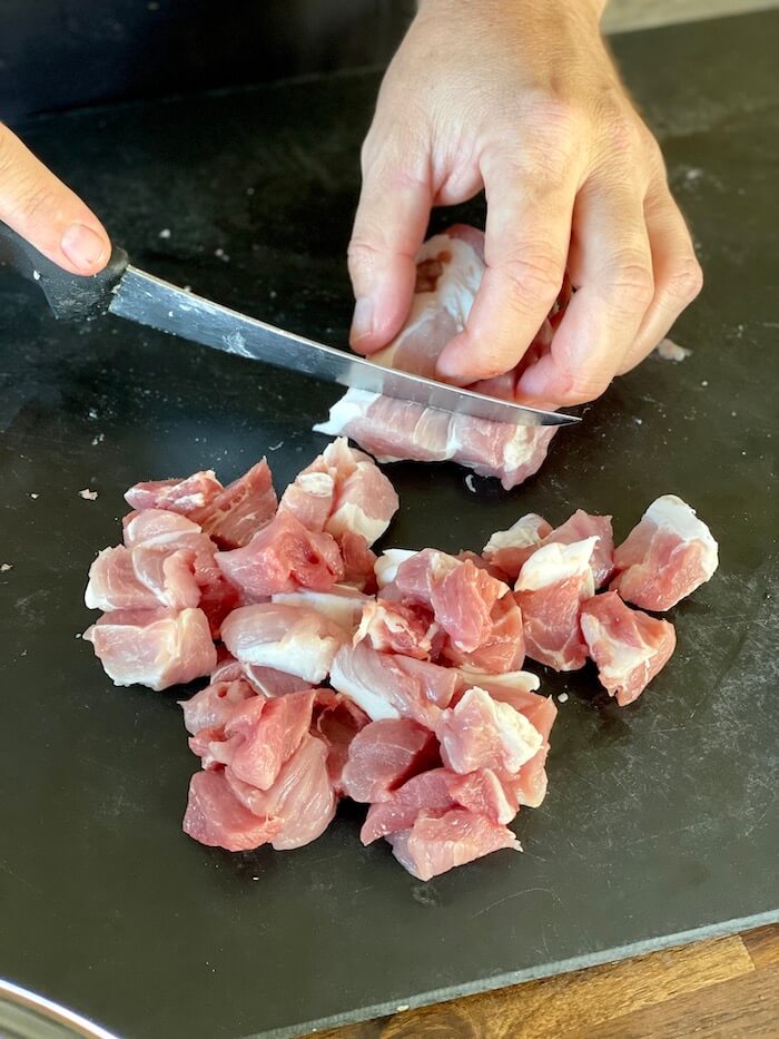cutting boneless pork butt into small dices