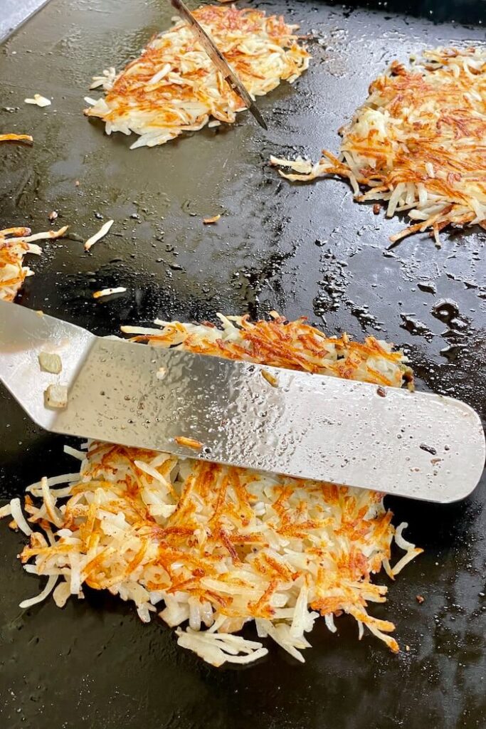 cooking crispy hash browns on a griddle