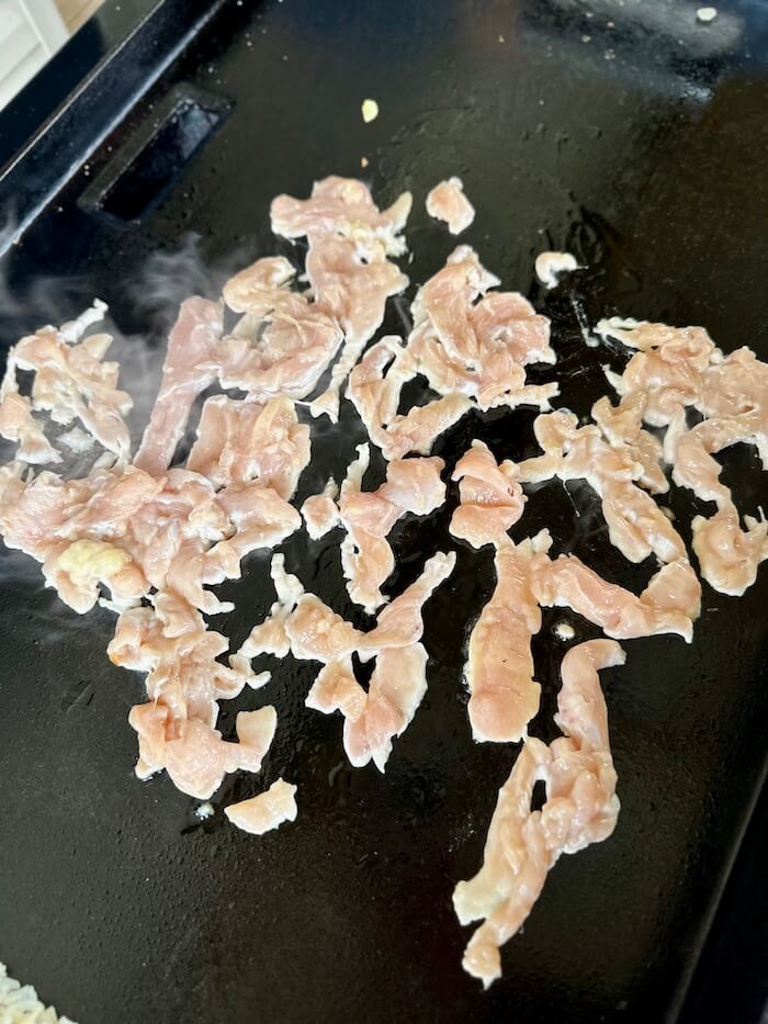 cooking sliced chicken on the Blackstone griddle